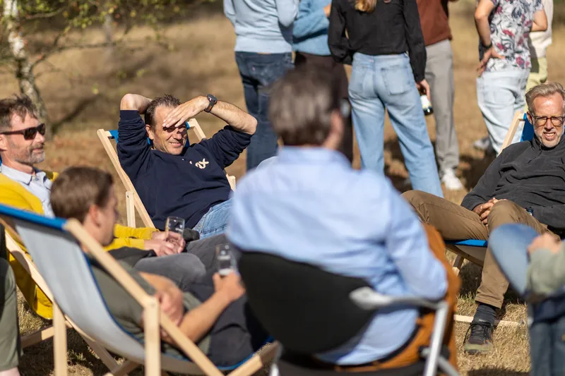 Collega's ontspannen in ligstoelen buiten tijdens een personeelsfeest