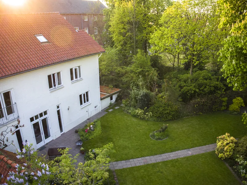 Dronefoto van een woning met tuin in het avondlicht