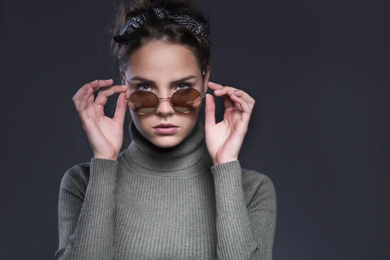 Portret van een vrouw die haar zonnebril omlaag trekt