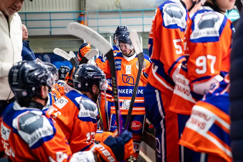 IJshockeyspelers bij de spelersbank in kleurrijke wedstrijdtruien
