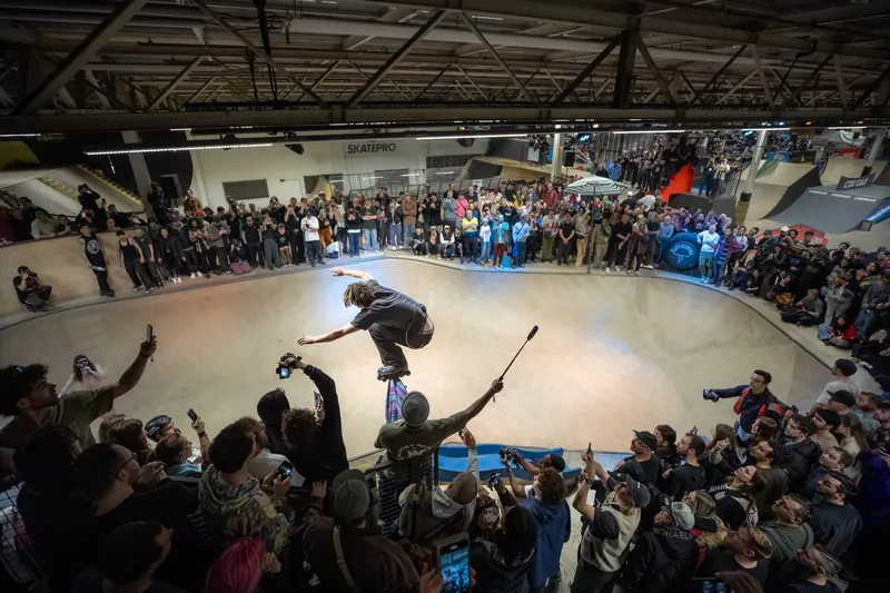 Skater in een bowl, omringd door een groot publiek tijdens een skate-evenement