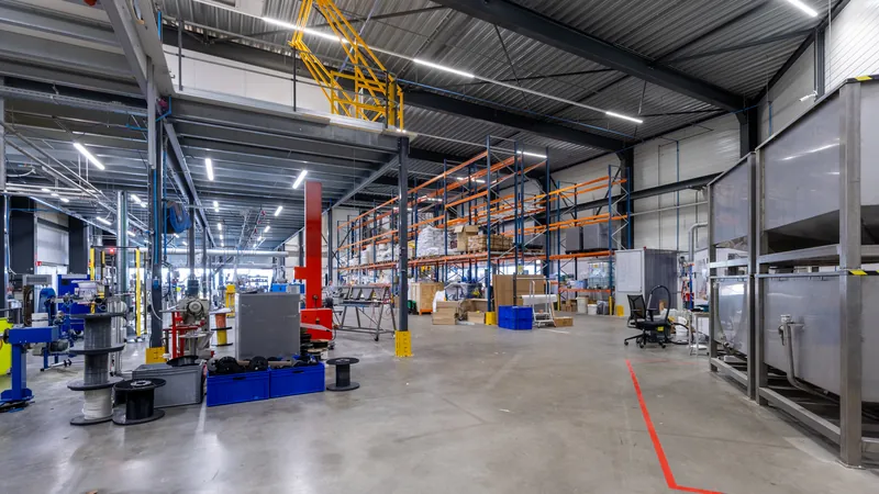 Interieur van een bedrijfshal met stellingen en kantoorruimte op de verdieping